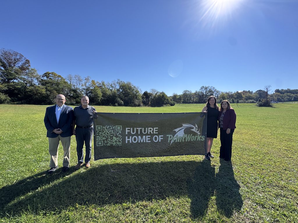 Economic Development staff poses with MELD Printworks CEO and President with a banner advertising the future home of MELD PrintWorks in Falling Branch Corporate Park